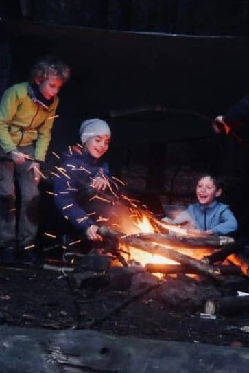 Children and adults gathered around a campfire