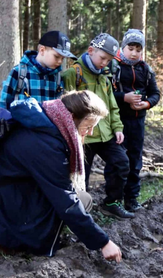 A group following animal tracks in the forest